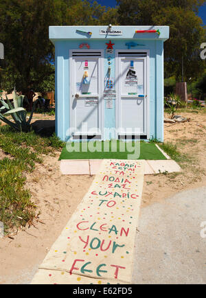 Mare greco wc pubblico, decorato con elementi a sinistra sulla spiaggia. Foto Stock