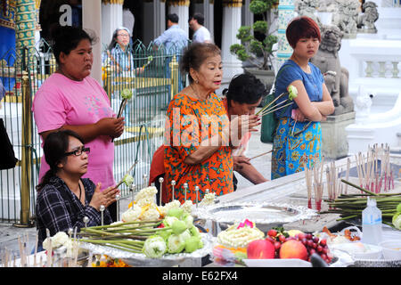Tailandese donne pregando, tenendo i fiori di loto e bastoncini di incenso - Wat Phra Kaeo Grand Palace di Bangkok in Thailandia Foto Stock