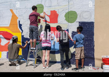 I volontari di raccogliere su Brook Avenue nel quartiere di Melrose del Bronx a New York per dipingere un murale Foto Stock