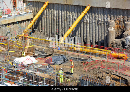 Pali in calcestruzzo accostati per formare seminterrato parete di ritegno con un grande diametro puntoni in posizione durante gli scavi Foto Stock