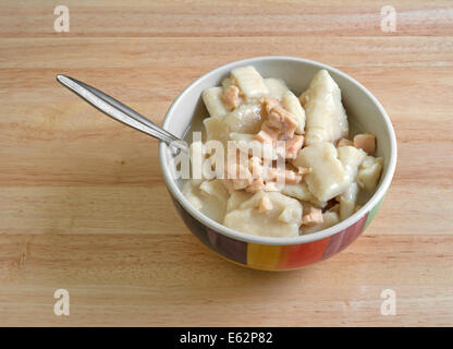 A che serve di pollo e gnocco la zuppa in una ciotola con il cucchiaio su una tavola di legno alto. Foto Stock