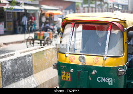 Un autista e la sua auto rickshaw di Delhi, India Foto Stock