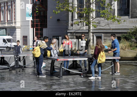 Un gruppo di adolescenti giocando a ping-pong all'aperto nel centro della città di Sheffield Foto Stock