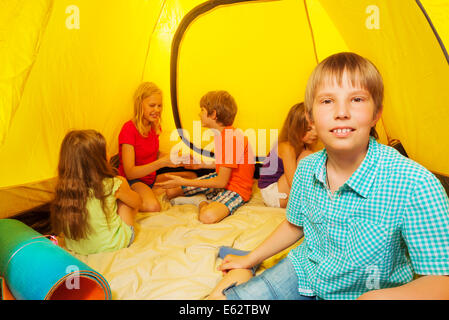 Ragazzo con gli amici in tenda da campeggio Foto Stock