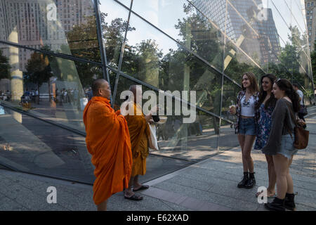 Manhattan, New York. Due monaci buddisti fotografia tre giovani ragazze di fronte il Museo 9/11. Foto Stock