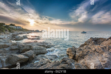 Tramonto sulla Ile Rousse nella regione della Balagne in Corsica con rocce in primo piano Foto Stock