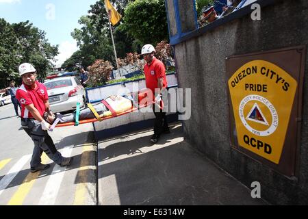 Quezon City, Filippine. 13 Ago, 2014. Soccorritori eseguire la simulazione di una vittima durante un terremoto trapano in Quezon City, Filippine, e il agosto 13, 2014. Il terremoto trapanare mira a valutare la preparazione alle situazioni di emergenza le capacità di polizia. Credito: Rouelle Umali/Xinhua/Alamy Live News Foto Stock