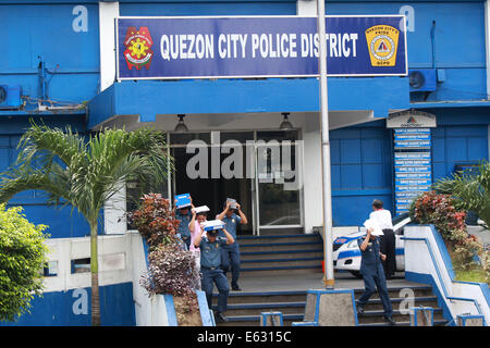 Quezon City, Filippine. 13 Ago, 2014. Poliziotti di coprire le loro teste durante un terremoto trapano in Quezon City, Filippine, e il agosto 13, 2014. Il terremoto trapanare mira a valutare la preparazione alle situazioni di emergenza le capacità di polizia. Credito: Rouelle Umali/Xinhua/Alamy Live News Foto Stock