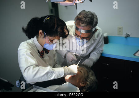 Anni ottanta dentista e assistente IL TRATTAMENTO paziente Foto Stock