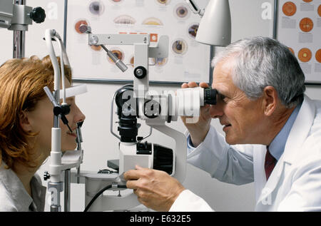 Anni Novanta maschi più anziani all'ottico optometrista esaminando dai capelli rossi OCCHI DI DONNA Foto Stock