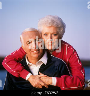 Anni Novanta Ritratto di giovane in tute da jogging guardando la telecamera donna in piedi con le braccia intorno all'uomo Foto Stock