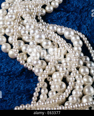 Anni sessanta anni settanta grande e piccola perla STRAND collane reale e finto PERLE POP sul tessuto blu Foto Stock