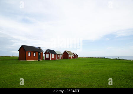 Fishermens tradizionali cabine di rosso in un vecchio villaggio di pescatori sulla costa dell'isola svedese Oland Foto Stock