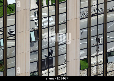 Le riflessioni di scena di strada & attraversamento pedonale nel vetro dello specchio del blocco di ufficio o ufficio edificio Monaco Foto Stock