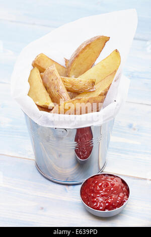 Patatine fritte fatte in casa in un piccolo cucchiaio di metallo con ketchup e Foto Stock