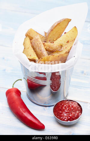 Patatine fritte fatte in casa in un piccolo cucchiaio di metallo con peperoncino e ketchup Foto Stock