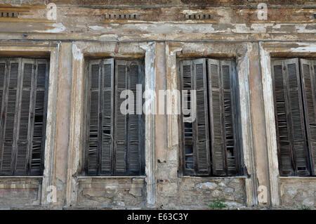 Rotture di persiane in legno e tagliò la parete di un edificio decaduto. Foto Stock