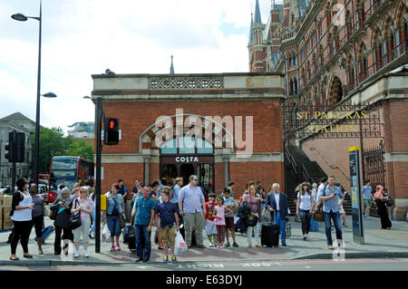 Pedoni in attesa di Cross Road, Kings Cross con la stazione di St. Pancras dietro il centro di Londra Inghilterra Gran Bretagna REGNO UNITO Foto Stock