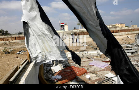 Rafah nella striscia di Gaza, Territori palestinesi. 13 Ago, 2014. Palestinesi ispezionare i resti di un centro di polizia, che testimoni ha detto è stato distrutto durante l'offensiva israeliana, vicino al confine Egypt-Gaza nella città di Rafah nel sud della striscia di Gaza, 13 agosto 2014. La minaccia di una nuova guerra a Gaza si profilava come l'orologio spuntata verso la fine dei tre giorni di cessate il fuoco senza un segno di un passo in avanti per i colloqui indiretti al Cairo tra Israele e i palestinesi di credito: Abed Rahim Khatib/immagini APA/ZUMA filo/Alamy Live News Foto Stock