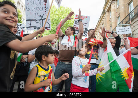 Whitehall, Londra, Regno Unito. Il 13 agosto 2014. Una grande folla di simpatizzanti si sono riuniti di fronte a Downing Street a dimostrare contro il primo ministro britannico inazione militare contro i militanti inflessibile in Iraq. La protesta e la veglia è stata organizzata dalla solidarietà contro ISIS campagna in associazione con il British Pakistani Associazione Cristiana. Nella foto: una giovane ragazza è data una candela come parte di un anti ISIS protesta e veglia in Whitehall, Londra. Credito: Lee Thomas/Alamy Live News Foto Stock