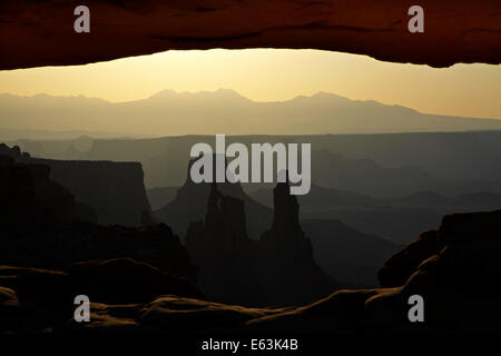 Sunrise oltre La Sal Mountains, Rondella donna Arch, e sotto Mesa Arch, il Parco Nazionale di Canyonlands, Utah, Stati Uniti d'America Foto Stock
