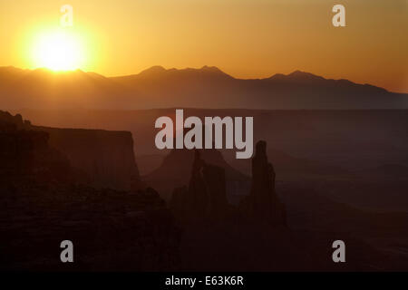 Sunrise oltre La Sal Mountains, Rondella donna Arch, Monster torre, e l'Aeroporto Torre, da Mesa Arch, Island in the Sky distretto, Foto Stock