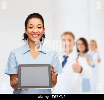 Donna sorridente medico o infermiere con il tablet pc Foto Stock