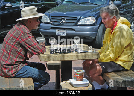 Due maschi adulti giocare a scacchi sulla tavola in downtown Mill Valley Park Foto Stock
