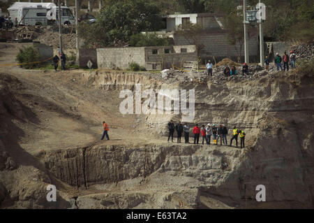 Quito, Ecuador. 13 Ago, 2014. La gente a guardare il sito di una frana di Quito, capitale dell'Ecuador, su agosto 13, 2014. Il tributo di morte pagato un poco profondo 5,1- terremoto di magnitudine in Ecuador la regione della capitale del rose per quattro mercoledì dopo un ricoverato uomo morto e i soccorritori recuperato il corpo di un uomo ucciso in una frana, i media locali hanno riferito. Credito: Santiago Armas/Xinhua/Alamy Live News Foto Stock