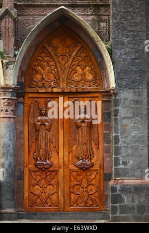 Una delle tre porte in legno della Cattedrale chiamato Basilica de la Virgen in Banos, Ecuador Foto Stock