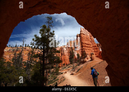 Gli escursionisti e tunnel su Queen's Garden Trail attraverso hoodoos, Parco Nazionale di Bryce Canyon, Utah, Stati Uniti d'America Foto Stock