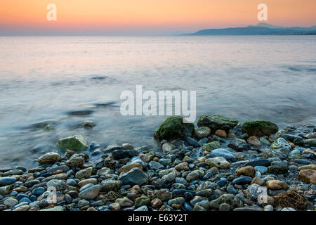Le onde del mare il gioco linea Pietra di impatto sulla spiaggia Foto Stock