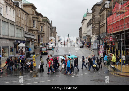 Pedoni che attraversano la giunzione Princes Street con Hanover Street di Edimburgo in un giorno di pioggia Foto Stock