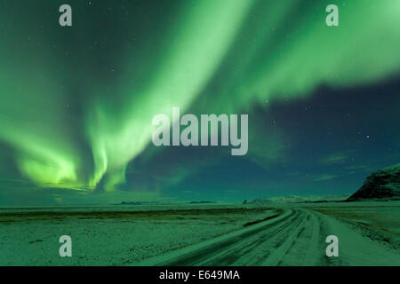 Luci del nord, Aurora Boreale, strada invernale con neve, Islanda Foto Stock