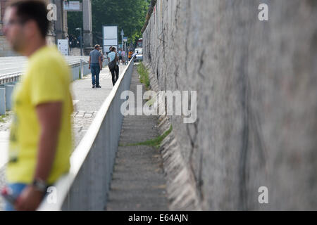 I turisti di visitare i resti del muro di Berlino il Niederkirchner Strasse vicino all'edificio Martin-Gropius a Berlino, Germania, 7 luglio 2014. Milioni di turisti arrivano a Berlino ogni anno e molti stanno pagando una visita ai resti e siti delle divise, anche 25 anni dopo il muro di Berlino è stato costruito. Foto: Maurizio Gambarini/dpa Foto Stock