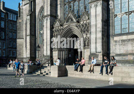 Turisti che si godono la serata sole estivo davanti alla Cattedrale di St Giles, Edimburgo Città Vecchia Foto Stock