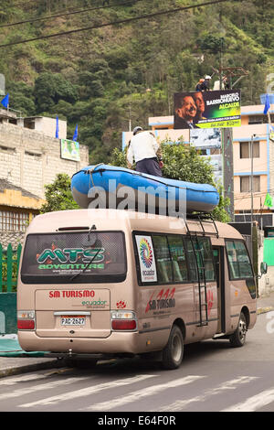 BANOS, ECUADOR - 25 febbraio 2014: persona non identificata in piedi su una barca di gomma legata al portapacchi di un minibus Foto Stock