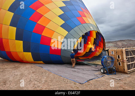 L'uomo gonfia il pallone ad aria calda per un volo. Moab, Utah, Stati Uniti. Foto Stock