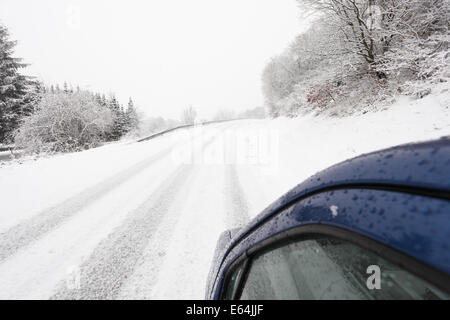 Auto su un paese nevoso strada in inverno Foto Stock