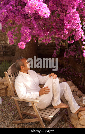 Uomo maturo seduti in giardino Foto Stock