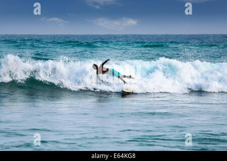 Silhouette di un surfista che cadono fuori bordo sulle onde nella famosa spiaggia in Sri Lanka. Foto Stock