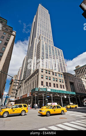 Medaglione giallo taxi passando dall'Empire State Building, New York, Stati Uniti d'America. Foto Stock