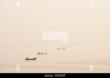 I pescatori nelle loro barche nella luce del mattino, Lago Thaungthaman, Amarapura, Mandalay Division, Myanmar Foto Stock