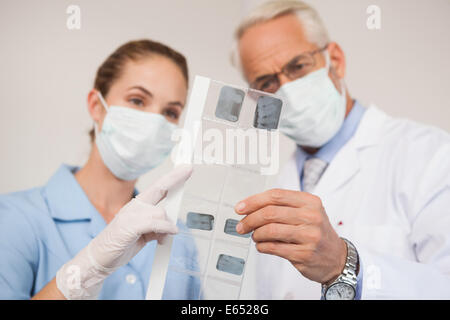 Dentista e assistente studiando i raggi x Foto Stock