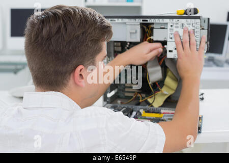 Giovane tecnico che lavora su computer rotto Foto Stock