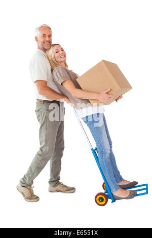 Coppia felice avendo divertimento con carrello e scatola di movimentazione Foto Stock