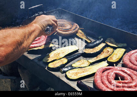 Salsicce e melanzane / avocado cottura su un barbecue barbecue Foto Stock