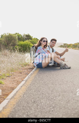 Giovane autostop sulla strada di campagna Foto Stock