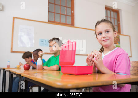 Carino alunni aventi il loro pranzo in aula Foto Stock