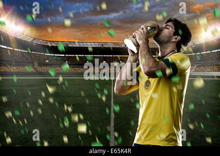 Calcio brasiliano player, celebrando il campionato con un trofeo in mano. Foto Stock